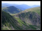 Sedlo Urdele do ktorého sa schádza po turistickom chodníku z kopca Iezer (2157 m, na fotke je vidieť iba časť na ľavej strane), napája sa na prašnú, kľukatiacu cestu (67C) a  pokračuje smerom ku kopcu Papuşa (2136 m).